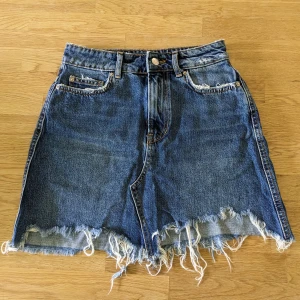 Jeanskjol - Jeanskjol med slitningar i storlek  34 från Gina Tricot.