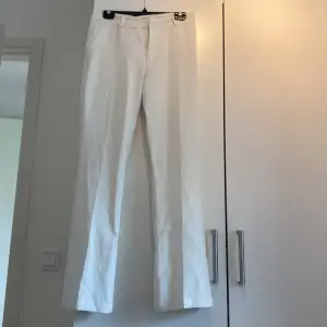 Vita kostymbyxor som är lite vida i benen, från bikbok i storlek 40.