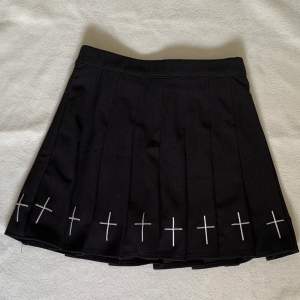 Svart kjol med kors storlek Xs. Jätteskönt material och har inbyggda shorts vilket är perfekt. Använd några gånger så fint skick. Okänt märke. Midja: 31cm, Längd: 36cm. 50kr + frakt