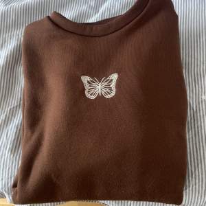 Fin brun sweatshirt med broderad fjäril på. Använd kanske 2ggr så väldigt mysig och ej sliten på insidan 🥰