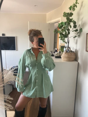 Grön Manchester klänning - Super snygg grön klänning i Manchester med knappar. Den perfekta gröna färgen och är i storlek XS. Säljer den då den inte kommer till användning och den är endast använd en gång. Snygg att ha lite på axlarna men även knäppt. 