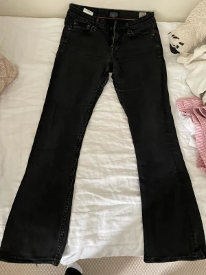 Lågmidjade bootcut jeans  - Lågmidjade bootcut jeans som inte kommer till användning har en liten skada vid inte lår som inte syns när du har på dig dem