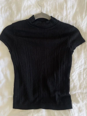 Svart topp - En svart topp köpt från Åhlens. Den är stretchig och sitter jätte fint. Den är även luftig och väldig luftig. En perfekt basplagg i mycket bra skick!!