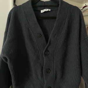  Cardigan  - En marinblå tröja köpt ifrån WeekDay i storlek S. Den är i mycket bra skick, tröjan har kommit till användning ett fåtal gånger. Det är tjock material och bra kvalitet. 