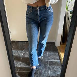 Jeans i mom-modell med slitna detaljer från Gina Tricot 