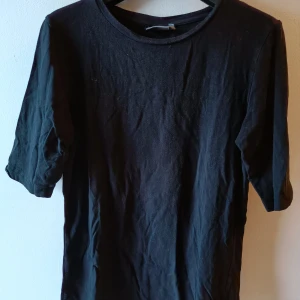 Trekvart T-Shirt I färgen svart.  - Trekvart T-Shirt I färgen Svart. Storlek S. 