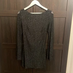 Svart klänning - Svart glittrig klänning från Parthea med öppen rygg, endast använd en gång och i storlek S