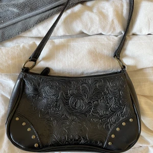 Svart handväska  - Svart handväska med snygga delaljer! Vet ej vart den är ifrån men fint skick. Kika gärna in mina andra annonser☺️