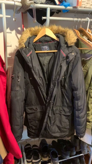 Vinterjacka - VINSON POLO CLUB Hewett Jacket Black - Liten i storleken. Lite använd men inga skador, avtagbar pälskrage, innerfickor, dragkedja och knappar. Skickas INTE, utan hämtas på plats. Katter i hemmet för dom som har kattallergi.