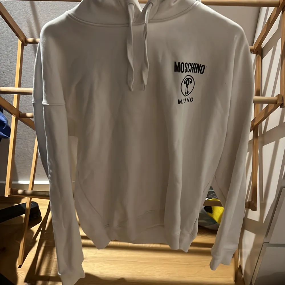 Moschino hoodie i storlek 52 (cirka M/L). Köpt på nk för cirka 2 år sen.  Har små fläckar vid bröstet som knappt syns om man inte tittar super nära, så därför ett lite billigare pris, nypris cirka 3200.. Hoodies.