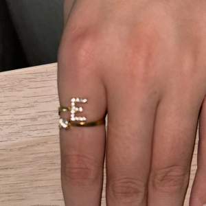 Guld ring med ett E 