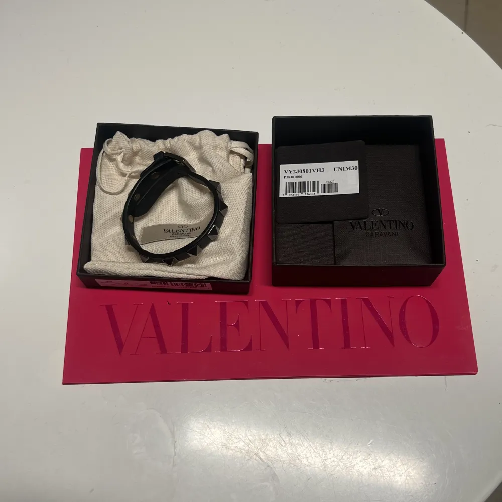 Mörkblått valentino armband med gråa nitar, skick 8,5/10, dm för rågor och bilder eller frågor om pris. Accessoarer.