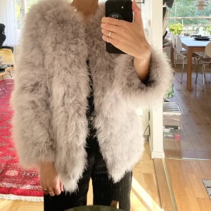 Pälsjacka strutsfjädrar  - Pälsjacka från Pello Bello av strutsfjädrar (äkta). Köpt för 1699 kr. Perfekt över klänning svala sommarkvällar! Använd ett fåtal gånger. Fint skick.