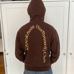 Stockholm Surfboard Club Hoodie - Säljer denna Stockholm Surfboard Club Hoodie då den har blivit för liten och inte används. Jag är 183 cm och bär storlek S på bilden. Den är använd men ändå i väldigt gott skick! Inga hål eller slitningar! Nypris 3100 kr😁