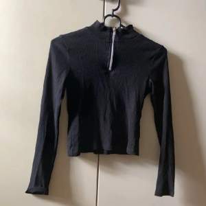Säljer denna snygga svarta ribbade tröjan med dragkedja, från Kappahl då den blivit för liten. Är i bra skick!