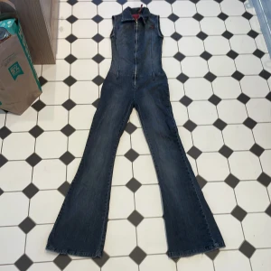 Jumpsuit - Figurformande byxdress. Säljer då den blivit för liten. Stretchigt material och utsvängda ben. Innerbenslängd 79cm 