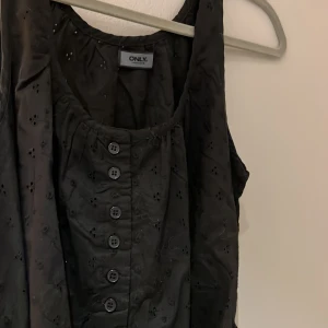 Svart sommarklänning med knytdetalj - Svart mönstrad klänning med knytdetalj från Only. Strl S