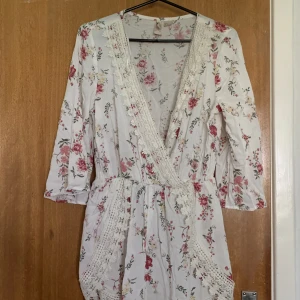 Playsuit - Playsuit från hm med spetsdetaljer. Knappen uppe på toppen har tyvärr lossnat så den går inte stänga hela vägen (andra bilden).