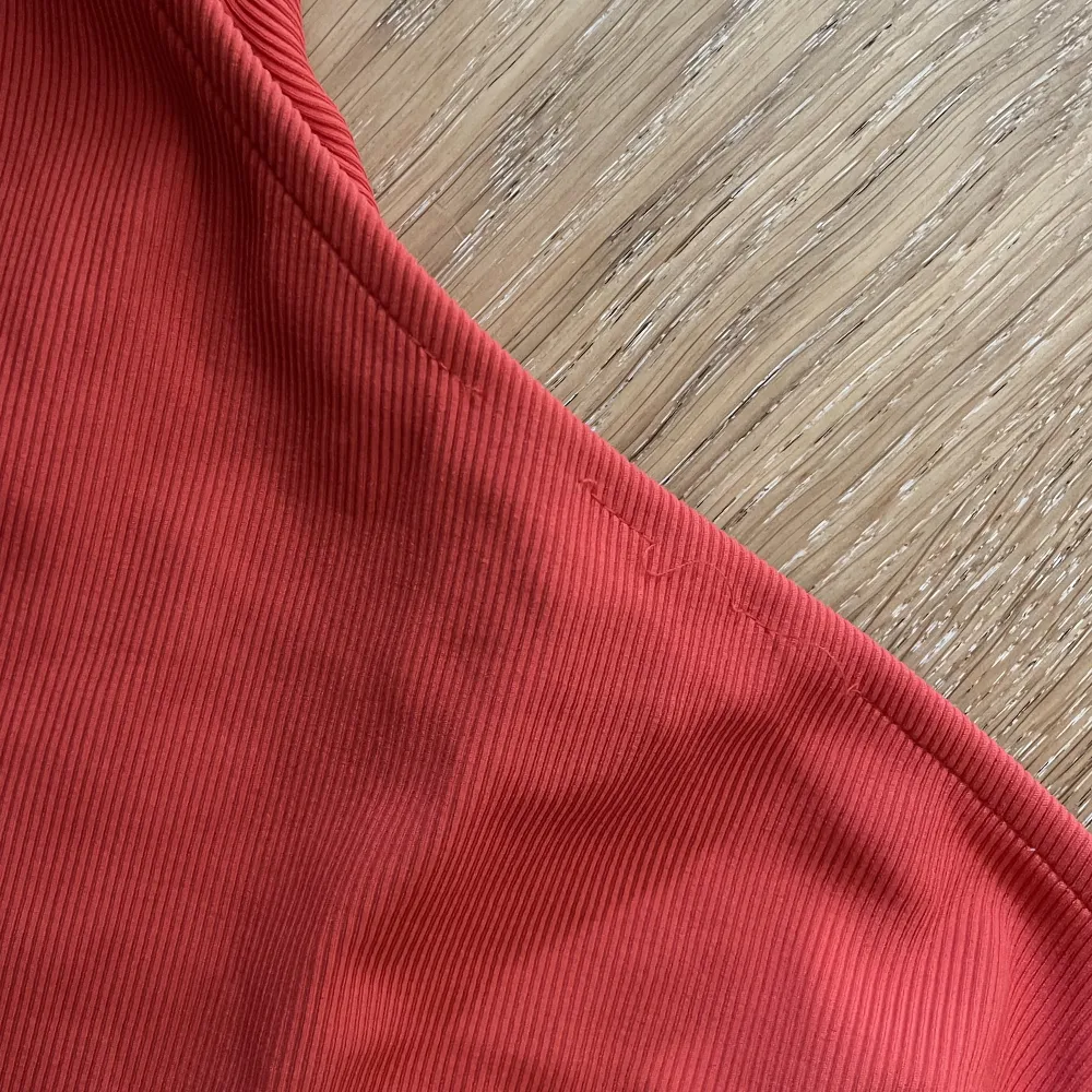 En röd oneshoulder från stradivarius som knappt är använd. Sömmen har lossnat lite längst fram men syns knappt när man har den på ❤️. Toppar.