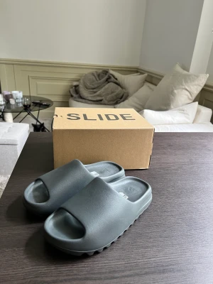 Yeezy slides storlek 43 (nya) - Helt oanvända, säljer då dem var för små för mig. Modellen heter slate grey 