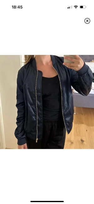 Jacka - Bomberjacka i blank mörkblå, strl xs i fint skick