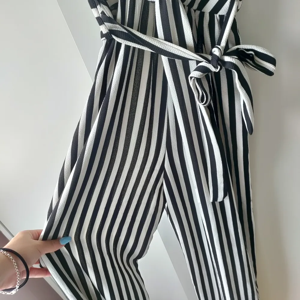 En randig jumpsuit köpt i Danmark. Den har väldigt flowiga ben och ett otroligt material. Knyte vid midjan. Skulle säga att storleken varierar mellan Xs till säkert en M. Beror på lite längd, vikt och byst!. Klänningar.