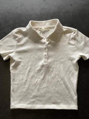 En vit nästan oanvänd croppad t-shirt med krage. Bomullm mix