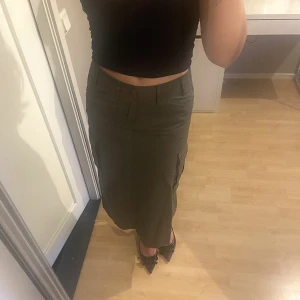 Cargokjol - Grön cargokjol från Brandy Melville endast använd fåtal gånger, nyskick. One size, passar 34/36. Minikjols som går till mitten av vaden på mig som är 165. 