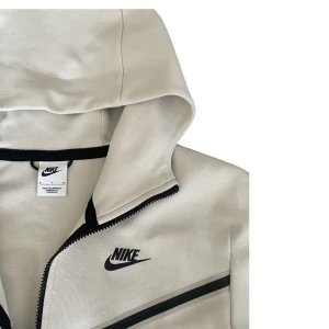 Nike tech - Kräm/Vit Nike teck i storlek M Skick: aldrig använd pga för stor på mig.  Finns att köpa med byxor i set (1300kr)