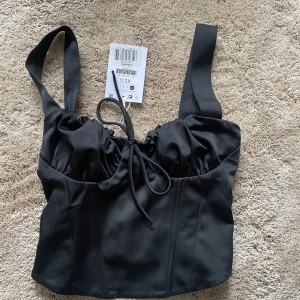 Topp från Bershka  - Svart korsett-topp från Bershka. Helt ny med prislapp kvar 