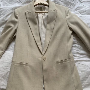 Ljus kavaj  - Kavaj i beige från hm. Storlek 38. Finns små tecken på användning. 