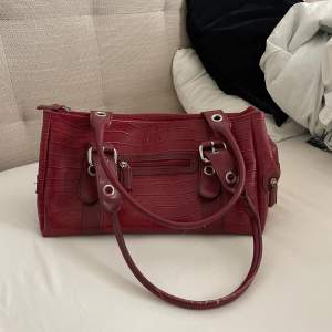 En cool röd väska i skinnimitation. Har en ”vintage” look. 