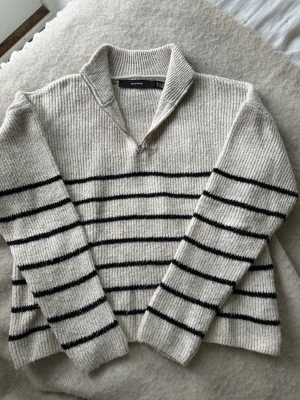 Stickad tröja  - Sugen på en tröja? Jag säljer denna stickade tröja i beige med svarta ränder. Den har en liten dragkedja där fram och är i bra skick. Per-Erik inför sena sommarkvällar eller nu till hösten. 