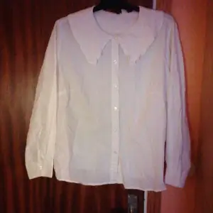 Vit skjorta med en frail krage från H&M i storlek XL från kvinn avdelningen. 