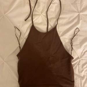 Ett brunt linne med knytning i nacken 🩵 Använd ett par gånger 💙