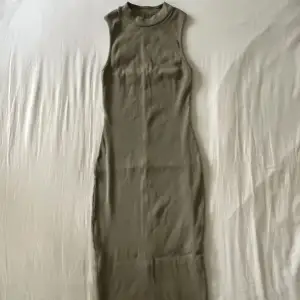 Lång olivfärgad bodycon klänning med slits på baksidan. Begagnat skick men inga fläckar eller hål! Storlek XS men passar även S🫶💕