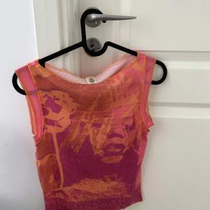 Söt rosa/orange linne med tryck, från urban outfitters, jättebra skick och använd en gång. Sitter tajt. 