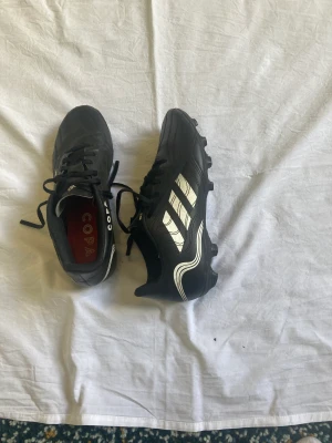 Adidas copa fotbollsskor  - Svarta adidas copa fotbollsskor knappt andvända i storlek 41 1/3 Väldigt bra skor om man vill ha några som håller länge dem är gjorda av läder och har en stark och stabil sula som funkar på både konstgräs och natur gräs