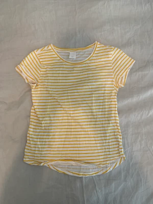 Randig t-shirt  - Vit och gulrandig t-shirt från H&M i storlek S. Knappt använd