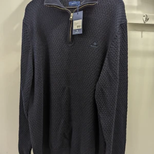 Gant Sweatshirt Stickad - Gant honeycomb half zip sweatshirt. 100% bomull stickad med ribbad ståkrage. Broderad logga. Marinblå.. Aldrig använd. Felköp