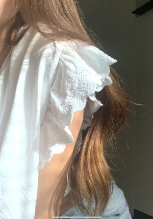 Volang topp - Supersöt cropped vit volang topp. Står ej märke eller storlek, men passar bra på mig som har S. Har tyvvär några mindre defekter, (b.la på kragen se bild 3) men är annars i bra skick. Passar Stockholmsstil💫 Fina mönster på ärmen❣️