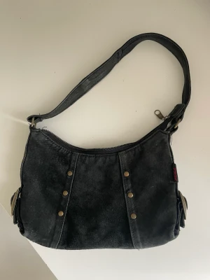 Handväska - Svart handväska med detaljer Köpt second och i väldigt bra skick 
