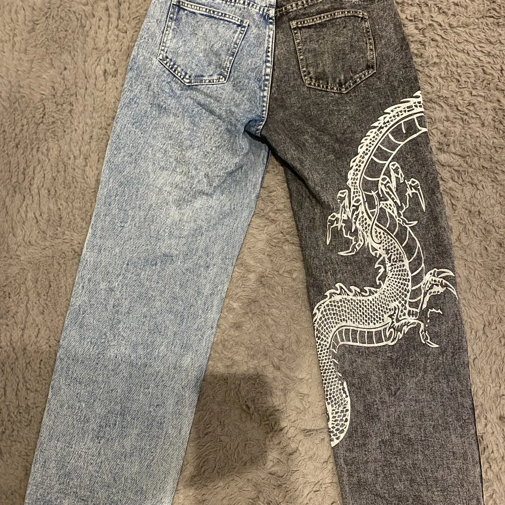 Ett par skit snygga jeans, ena benet är blått och det andra mörk grått med en kinesisk drake på🩵🩶🐉 Har bara haft på mig de typ en gång, så de är i princip typ oanvända, skriv om du vill ha mer specifika mått på byxorna🌸Prisändring kan ske vid snabbt köp. Jeans & Byxor.