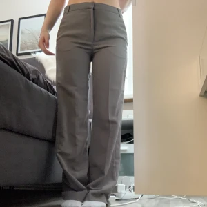 grågröna kostymbyxor - grågröna kostymbyxor mid waist, full length. säljer pga för långa och breda i i benen för min smak. wide leg och ena bakfickan har en ”fick flärp?” ( se bild 2) bara testade aldrig använda. 