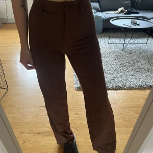 Bruna kostymbyxor  - Bruna kostymbyxor från Monki i storlek 32, sparsamt använda, 50kr