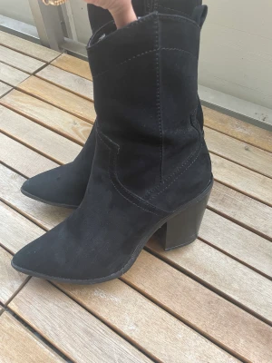 Cowboyboots  - Svarta cowboyboots. Så snygga i mockaimitation. Storlek 38☀️ så snygga båda till byxor så man ser den spetsiga klacken. Eller till kjol/klänning.