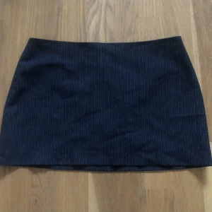 Kort randig kjol - Jättesnygg kjol med vita ränder som tyvärr är för liten. Passar lågmidjat för någon som är XS, och den är väldigt kort. Kjolen är rätt tunn och har en liten innekjol med dragkedja baktill!