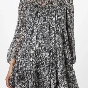 Klänning - Den är mycket mer som på första bilden men det syns inte på andra fotot. Svartvit med lite skimmer. Ärmarna är i tunnare och genomskinligare material! St 38 men passar mig som vanligtvis har 34-36