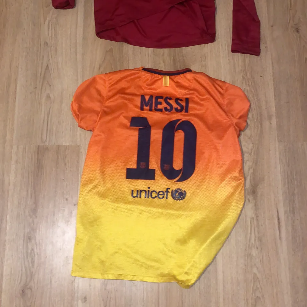 Vin röda långarmade Barca tröjan storlek 147-158 300 kr priset kan sänkas. Orange Barca t-shirt med Messi i ryggen storlek158-170 250kr. Båda är äkta. Priset kan sänkas . T-shirts.