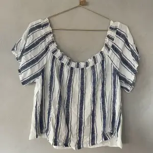 Offshoulder blus i linne liknande tyg. 